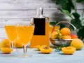 Orzeźwiający drink z likierem brzoskwiniowym, podany w eleganckich kieliszkach, z owocami i butelką w tle.
