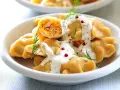Pyszne pierogi z farszem, polane sosem i posypane koperkiem. Idealne co na obiad dla gości, by ich zachwycić.