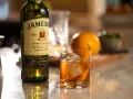 Old Fashioned na bourbonie czy na żytniej whisky? Jameson Irish Whiskey obok drinka z pomarańczą i lodem.