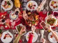 Uroczysta kolacja: pieczona kaczka z jabłkami i warzywami kontra pieczona gęś. Rodzina świętuje przy stole pełnym smakołyków.