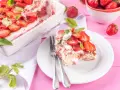 Tiramisu klasyczne kontra tiramisu truskawkowe. Porcja deseru z truskawkami i miętą na talerzu, obok naczynie z deserem i miseczka owoców.