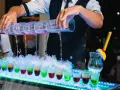 Barman nalewa kolorowe shoty na weselu. Zastanawiasz się, ile bierze barman na weselu za taką atrakcję?