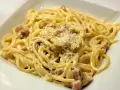 Pyszne spaghetti carbonara ze śmietaną, posypane parmezanem. Idealne na szybki obiad.