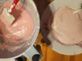 Różowa masa na makaroniki w misce i na talerzyku. Szpatułka miesza kremową konsystencję. Idealny makaroniki przepis w przygotowaniu.