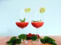 Dwa kieliszki orzeźwiającego drinka truskawkowego z rumem, ozdobione plasterkami kiwi i miętą. Na drewnianym blacie leżą świeże truskawki i listki mięty.