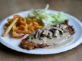 Ryba smażona w panierce z sosem grzybowym, frytkami i surówką. Wygląda pysznie!