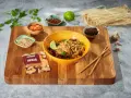 Curry z kurczakiem czy stir-fry z wołowiną? Na desce składniki do dania z makaronem ryżowym, imbir, sezam, chili, czosnek i limonka.
