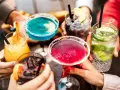 Kolorowe drinki z burbonem, owocowe i orzeźwiające, unoszone w radosnym geście.