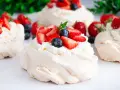 Klasyczna Pavlova z owocami i kremem lub małe beziki z kremem. Pyszne, lekkie desery.