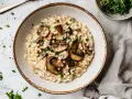 Kremowe risotto z grzybami, pachnące ziołami, czeka na Ciebie. Czy wolisz je od Paelli z owocami morza?