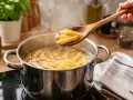 Penne penne w gotującej się wodzie, sprawdzanie gotowości. Oto jak ugotować makaron idealnie.