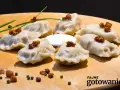 Pyszne pierogi ruskie kontra pierogi z mięsem, podane na desce z chrupiącym skwarkami i śmietaną.