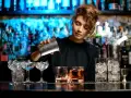 Barman w Grecji przygotowuje drinki. Ciekawe, ile zarabia barman w Grecji, pracując w takim miejscu.