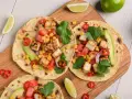 Zdrowy obiad dietetyczny: tortille z grillowanym tofu, kukurydzą, pomidorami, awokado i kolendrą.