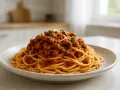 Pyszne Spaghetti Bolognese przepis na talerzu, z bogatym sosem mięsnym i świeżą bazylią. Idealne danie dla całej rodziny.
