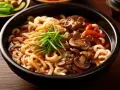 Miseczka z makaronem udon, grzybami, mięsem i szczypiorkiem. Czy to makaron udon mrożony czy suszony, smakuje wyśmienicie!