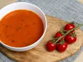Aksamitna zupa pomidorowa z ryżem czy z makaronem? Na desce leżą świeże pomidorki koktajlowe, idealne do tej klasycznej potrawy.