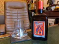 Cointreau kontra Triple Sec w koktajlach: butelka Cointreau i pusty kieliszek na biurku.