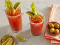 Dwa Bloody Mary: jedno na soku pomidorowym, drugie na passacie. Oba ozdobione łodygą selera, limonką i oliwką.