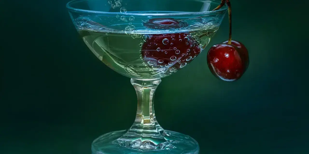 Gin lubelski czy Seagram’s do domowych drinków? W kieliszku bąbelki unoszą się wokół wiśni, tworząc orzeźwiającą kompozycję.