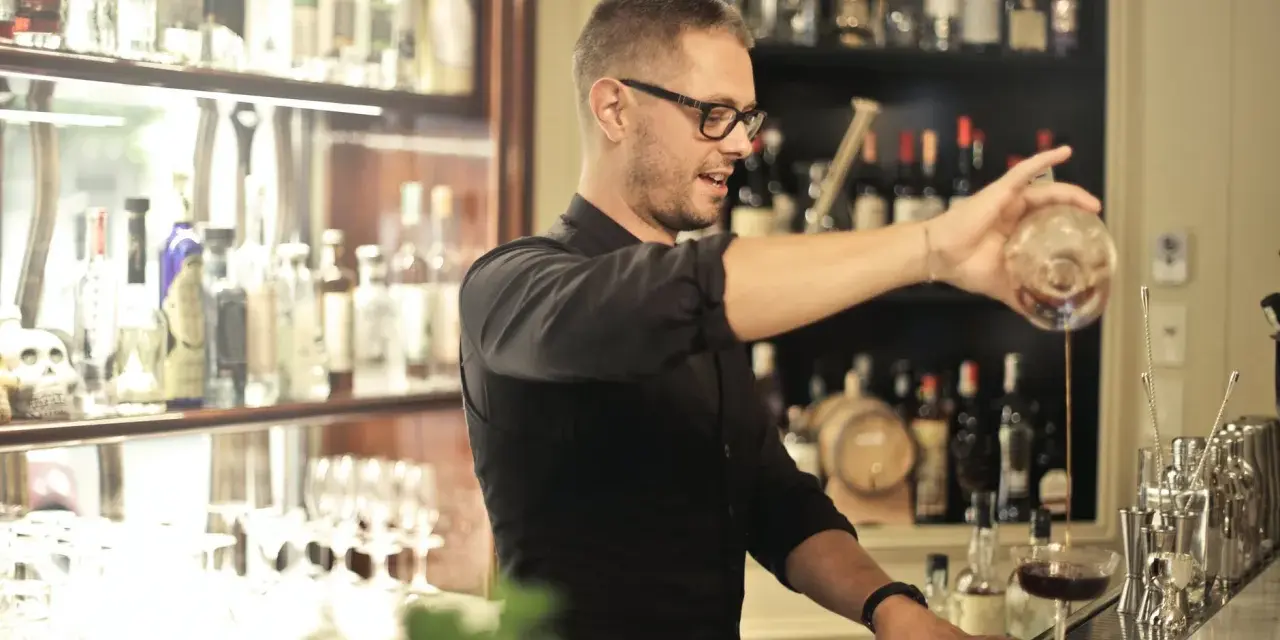 Barman po kursie przygotowuje drinka. Zastanawiasz się, ile zarabia barman po kursie?