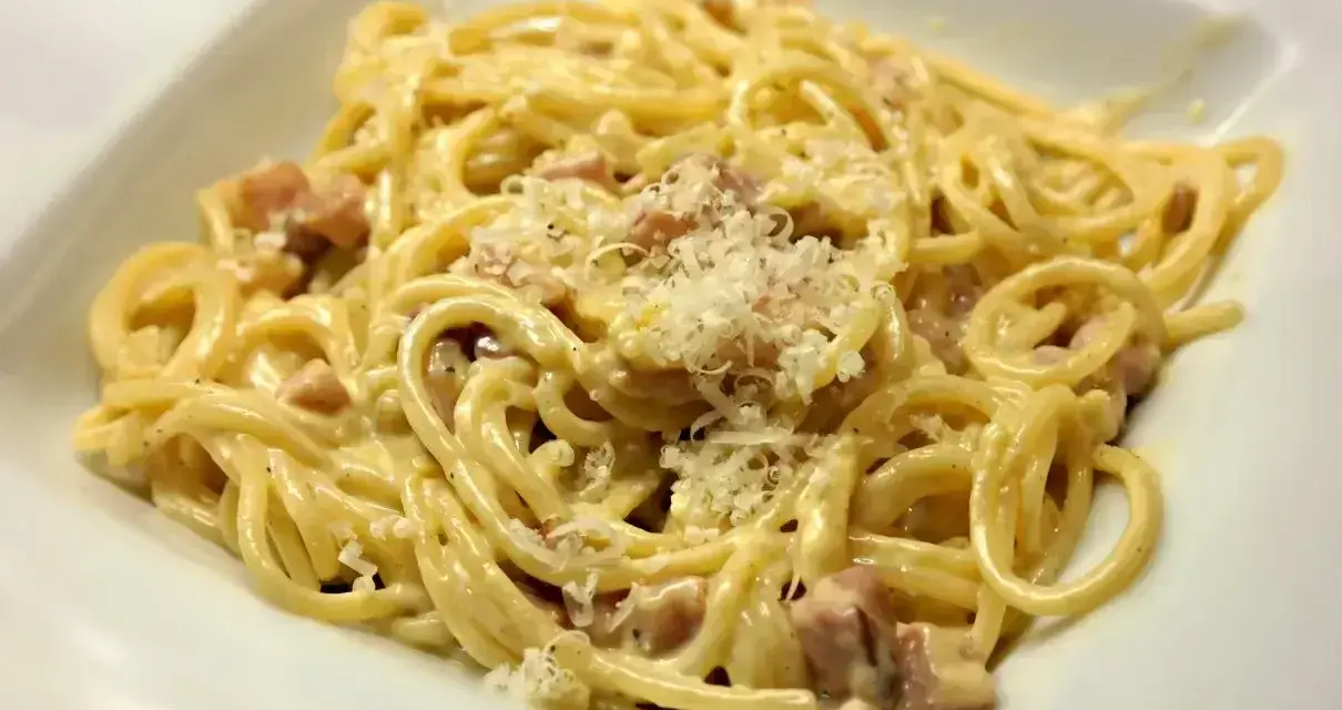 Pyszne spaghetti carbonara ze śmietaną, posypane parmezanem. Idealne na szybki obiad.