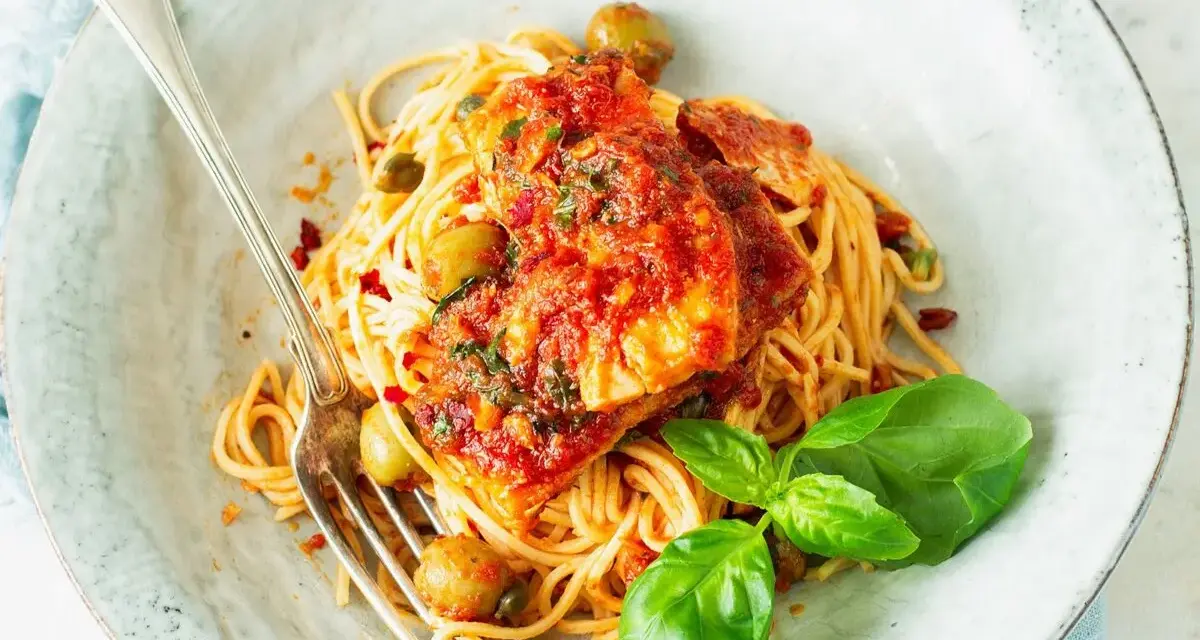 Spaghetti Puttanesca przepis: makaron z rybą w sosie pomidorowym, oliwkami, kaparami i bazylią. Pyszne danie gotowe do podania.