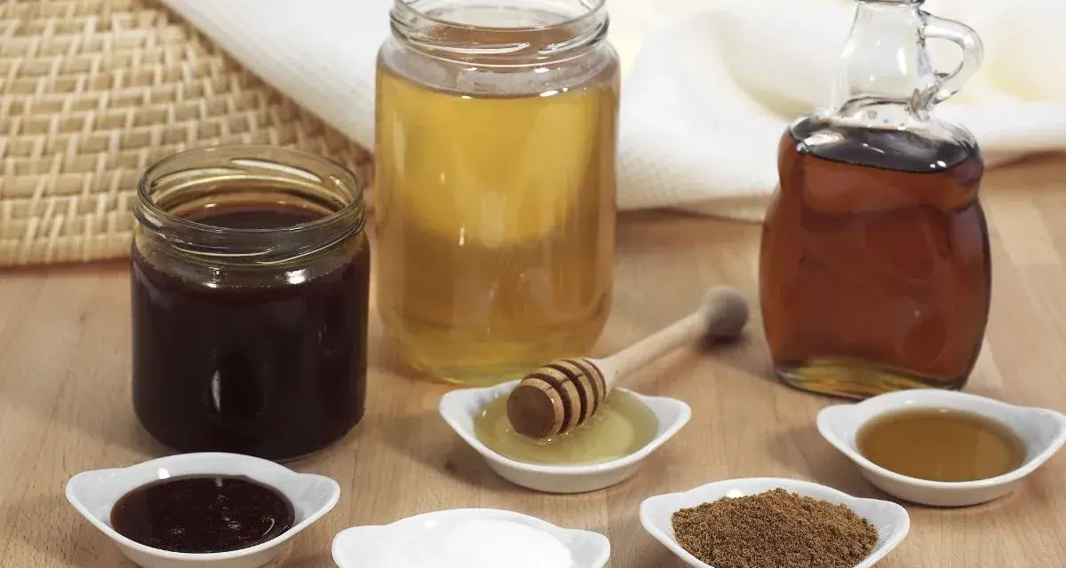 Domowy syrop cukrowy i kupny syrop barmański obok miodu i cukru.