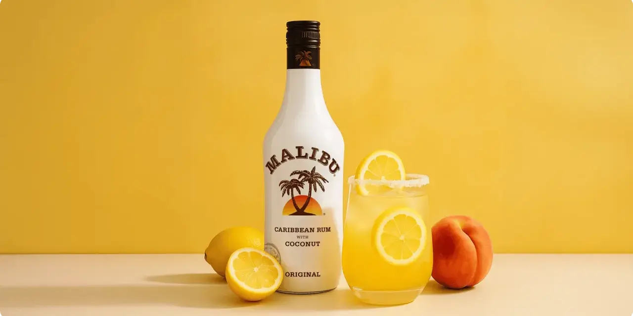 Orzeźwiający drink z malibu przepis: kokosowy rum, cytryny i brzoskwinia na żółtym tle. Idealny na lato!