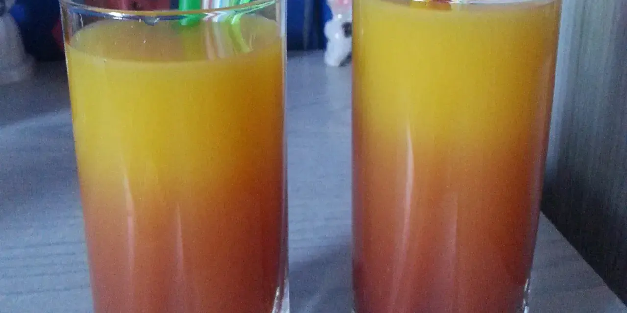 Dwa orzeźwiające drinki z sokiem malinowym, tworzące piękny gradient od czerwieni do żółci, gotowe do degustacji.