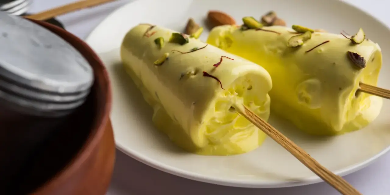 Dwa pyszne kulfi na patyku, posypane pistacjami i szafranem. Idealne na upalne dni, gdy szukasz prostego kulfi przepis.