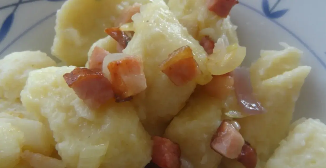 Kopytka z sosem i skwarkami z boczku, pyszne danie.