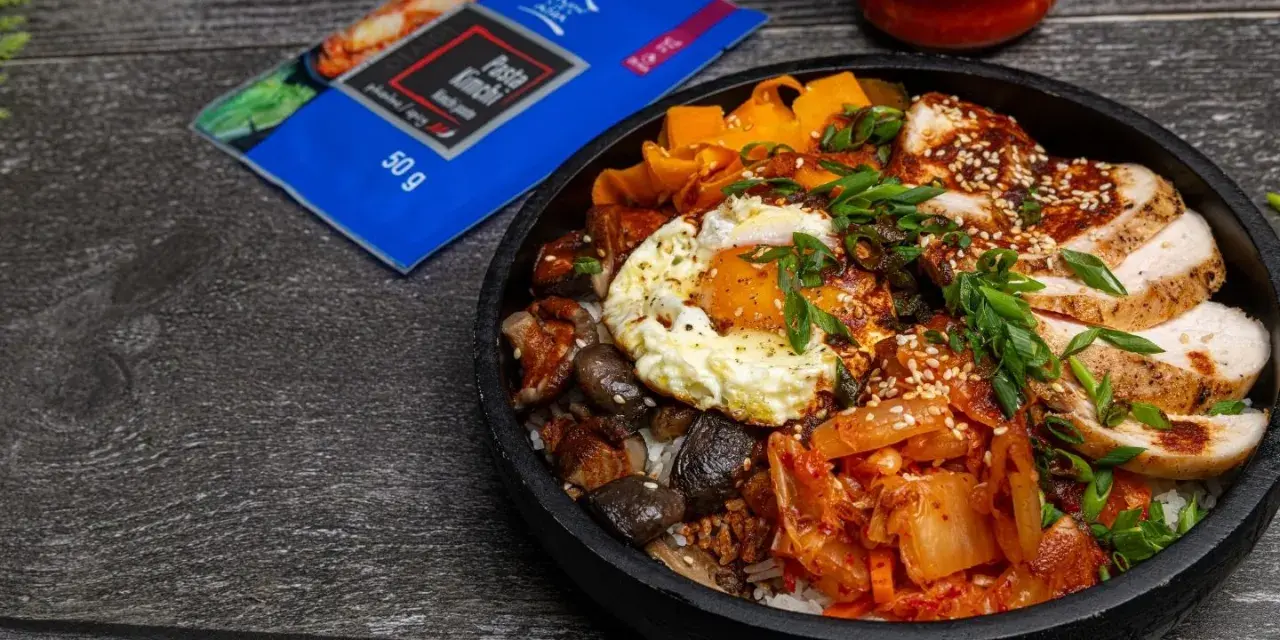 Pyszny Bibimbap przepis z kurczakiem, jajkiem sadzonym, grzybami, marchewką i kimchi. Idealny na szybki obiad.