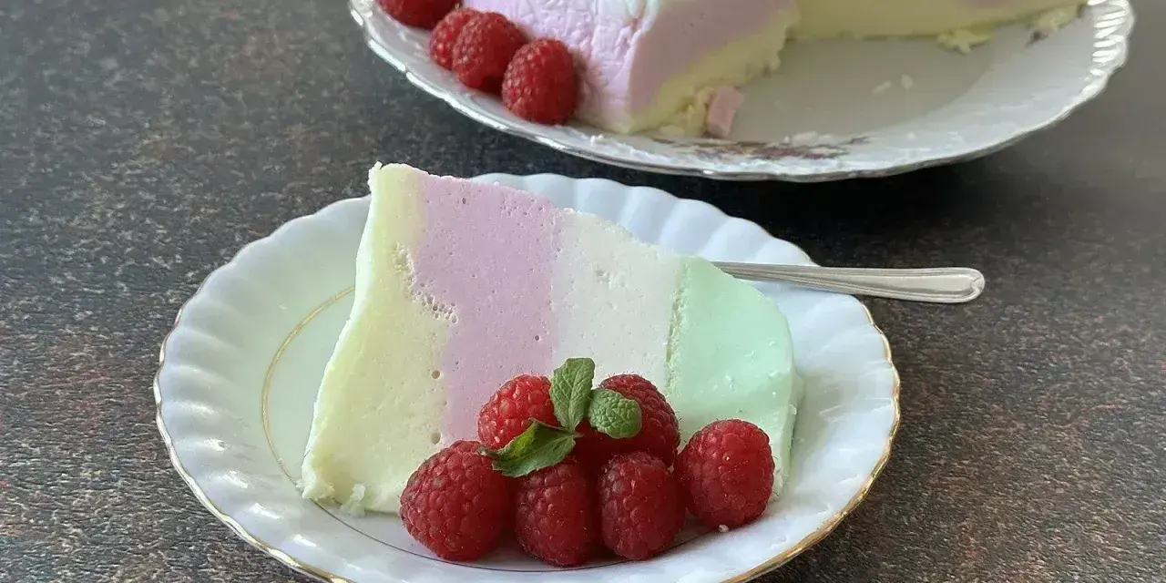 Puszysta pianka z galaretki i jogurtu w kolorach pastelowych, udekorowana malinami.