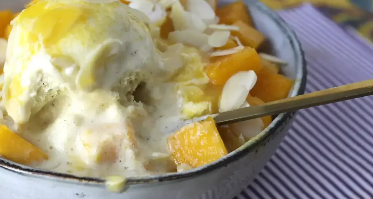 Pyszny deser Bingsu przepis: lody waniliowe z mango, płatkami migdałów i syropem.