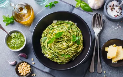 Pyszne spaghetti z pesto, idealne co na obiad zamiast mięsa. Podane z parmezanem, orzeszkami pinii i świeżą bazylią.