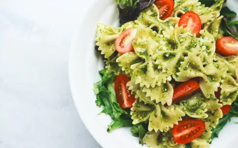 Makaron farfalle z pesto, pomidorkami koktajlowymi i sałatą. Idealny pomysł, co jeść na obiad żeby schudnąć.