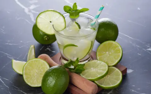 Orzeźwiająca Caipirinha przepis: świeże limonki, lód, mięta i drewniany muddler. Idealny drink na lato.