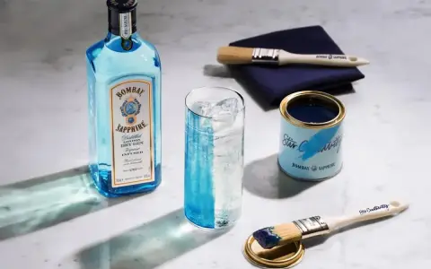 Butelka Bombay Sapphire, szklanka z lodem i drinkiem, puszka z farbą i pędzle. Jak pić blue gin? Stwórz własny drink!