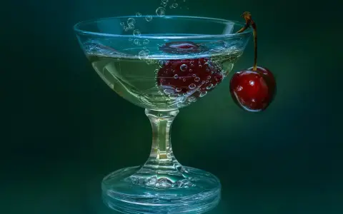 Gin lubelski czy Seagram’s do domowych drinków? W kieliszku bąbelki unoszą się wokół wiśni, tworząc orzeźwiającą kompozycję.