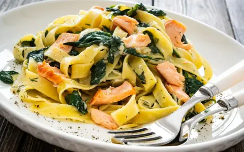 Makaron tagliatelle z łososiem i szpinakiem. Pyszny pomysł na obiad, który zadowoli każdego smakosza.