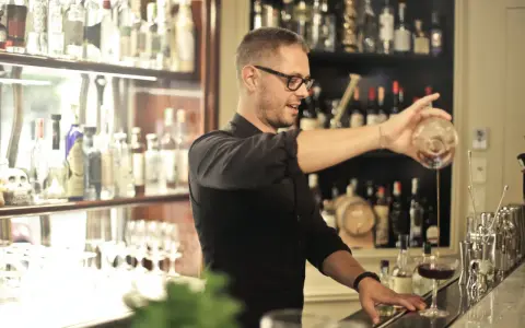 Barman po kursie przygotowuje drinka. Zastanawiasz się, ile zarabia barman po kursie?