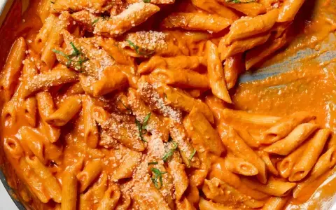 Penne rigate w kremowym sosie pomidorowym, posypane parmezanem i ziołami. Idealne na obiad, czy to penne lisce czy rigate, smakują wybornie.