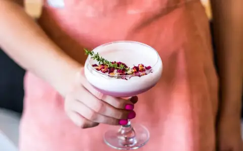 Różowy drink z płatkami róży i gałązką tymianku. To idealna alternatywa dla gin z tonikiem, gdy masz ochotę na gin z różową lemoniadą.