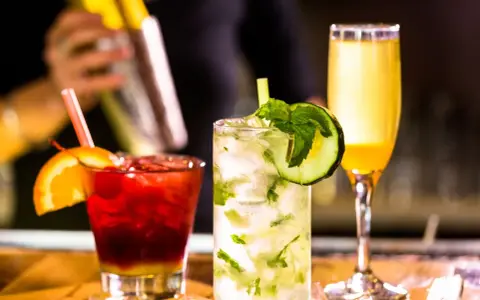 Mojito na białym rumie kontra Mojito na ciemnym. Trzy drinki: czerwony z pomarańczą, zielony z ogórkiem i żółty.