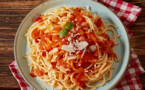 Pyszne spaghetti z sosem pomidorowym, parmezanem i bazylią. Czy to Makaron Barilla czy De Cecco? Trudno odróżnić!