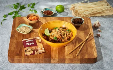Curry z kurczakiem czy stir-fry z wołowiną? Na desce składniki do dania z makaronem ryżowym, imbir, sezam, chili, czosnek i limonka.