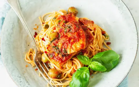 Spaghetti Puttanesca przepis: makaron z rybą w sosie pomidorowym, oliwkami, kaparami i bazylią. Pyszne danie gotowe do podania.