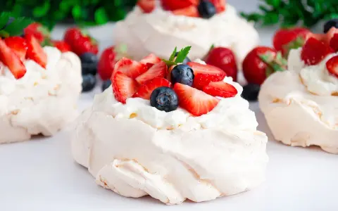 Klasyczna Pavlova z owocami i kremem lub małe beziki z kremem. Pyszne, lekkie desery.
