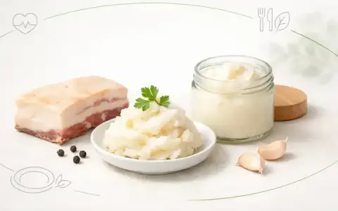 Smalec, czosnek i pieprz – składniki do tradycyjnego schabowego smażonego na smalcu, a obok słoik z tłuszczem roślinnym.